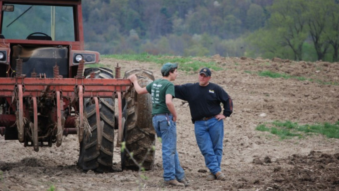 Ranchers Discuss By A Tractor